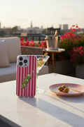 Phone case with striped design on a table with a cityscape background